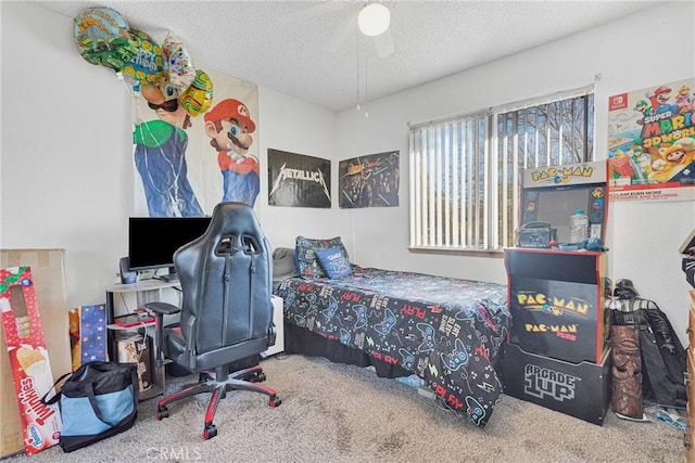 bedroom with ceiling fan, carpet floors, and a textured ceiling