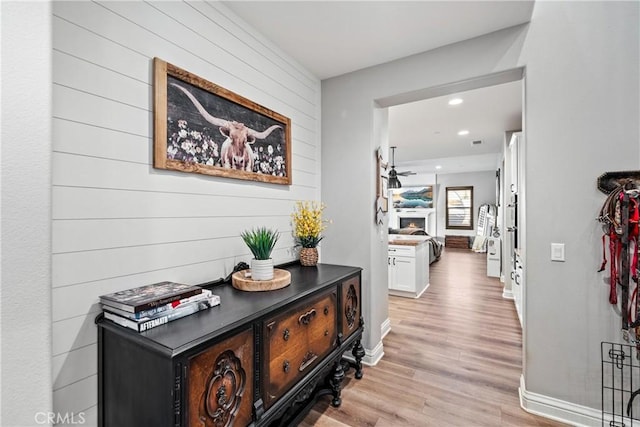 corridor with light hardwood / wood-style floors