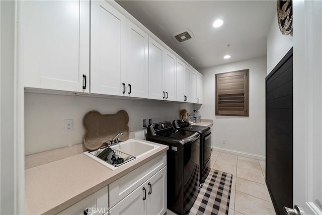 laundry area featuring cabinets, light tile patterned floors, sink, and washing machine and clothes dryer