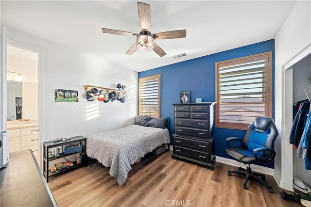 bedroom with hardwood / wood-style flooring, ceiling fan, and multiple windows