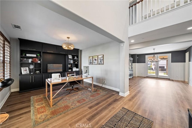 home office featuring dark wood-type flooring and a notable chandelier