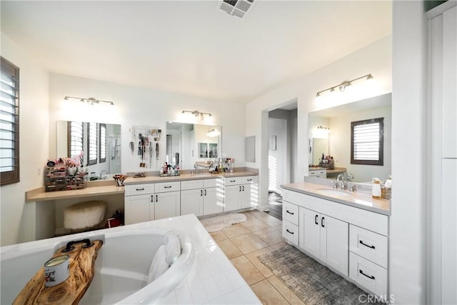 bathroom with vanity, tile patterned floors, and a tub to relax in