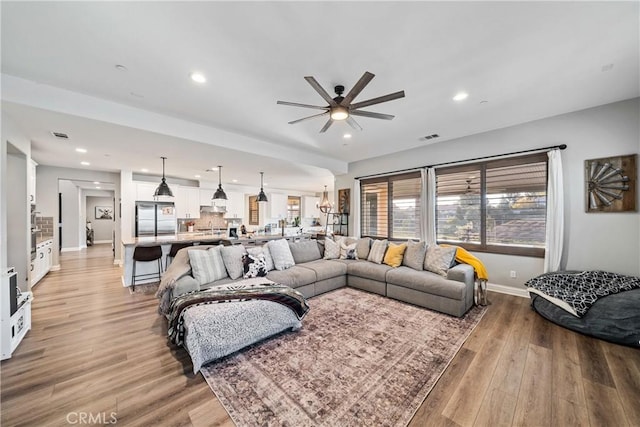 living room with ceiling fan and light hardwood / wood-style floors