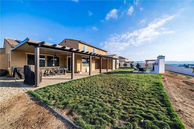 rear view of property featuring a yard and a patio area