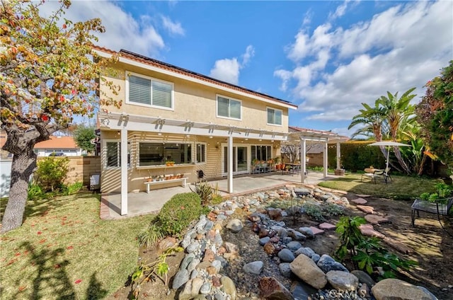 rear view of property featuring a lawn, a patio area, and a pergola