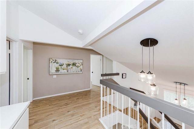 hall featuring light hardwood / wood-style floors and lofted ceiling with beams