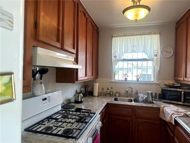 kitchen with sink, decorative backsplash, and white gas range oven