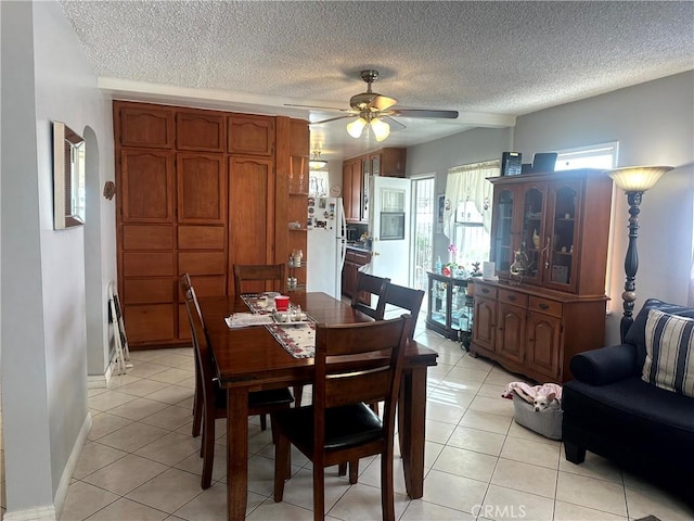 dining room with ceiling fan, light tile patterned floors, and a textured ceiling