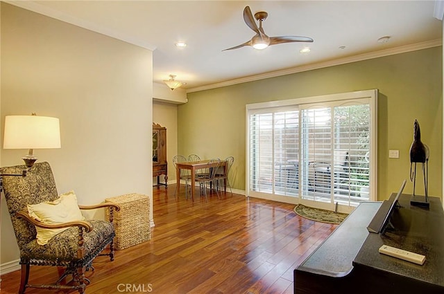 sitting room with hardwood / wood-style floors, ornamental molding, and ceiling fan