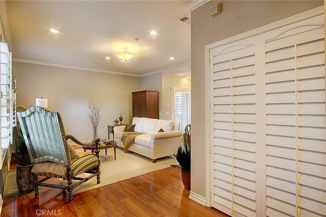 living area with ornamental molding and light wood-type flooring