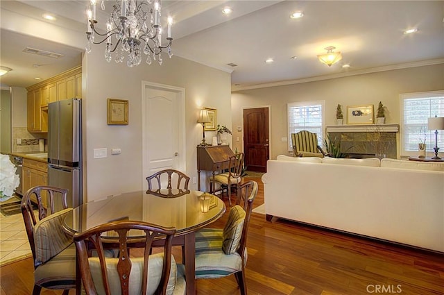 dining area with ornamental molding and dark hardwood / wood-style floors