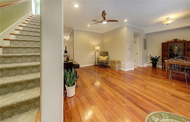 living room featuring hardwood / wood-style flooring, ornamental molding, and ceiling fan