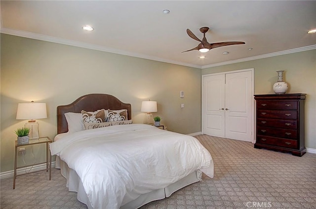 carpeted bedroom with crown molding, ceiling fan, and a closet