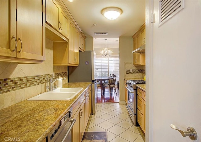 kitchen featuring sink, an inviting chandelier, backsplash, high end stove, and light tile patterned flooring