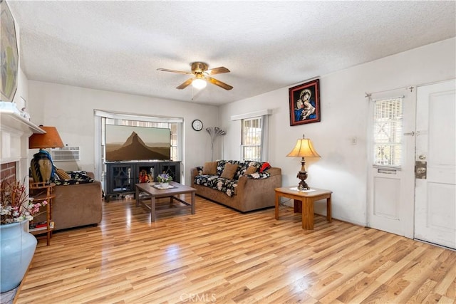 living room featuring plenty of natural light, light hardwood / wood-style flooring, and a textured ceiling