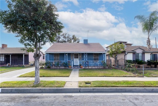 bungalow with covered porch and a front yard