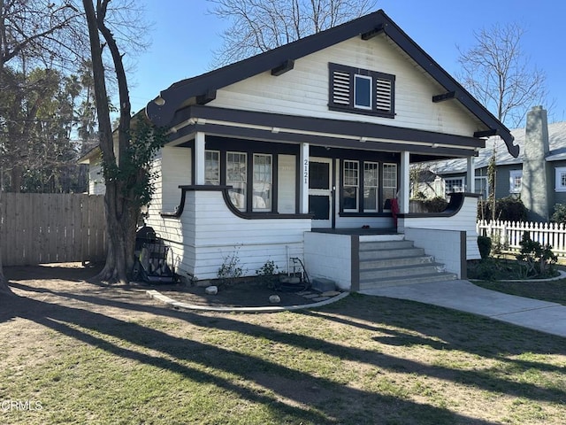 bungalow featuring a garage, a front lawn, and a porch