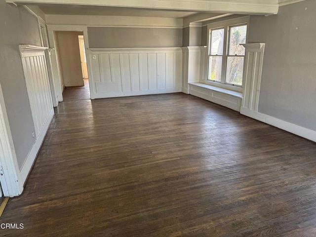 spare room with dark wood-style floors and baseboards