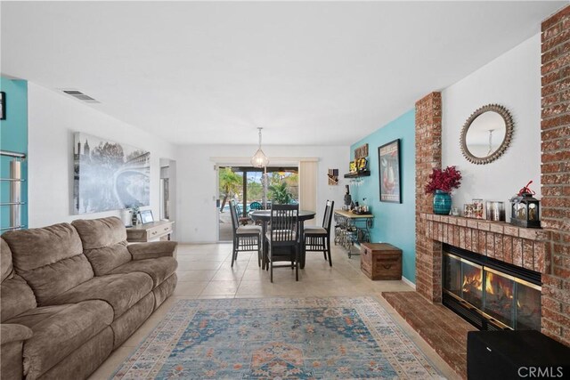 living room with a brick fireplace and light tile patterned floors