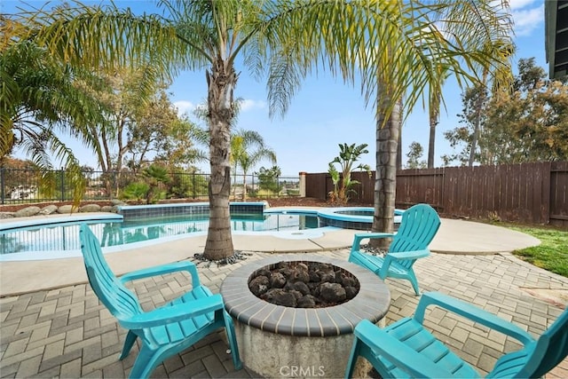 view of swimming pool featuring an in ground hot tub, a patio, and an outdoor fire pit