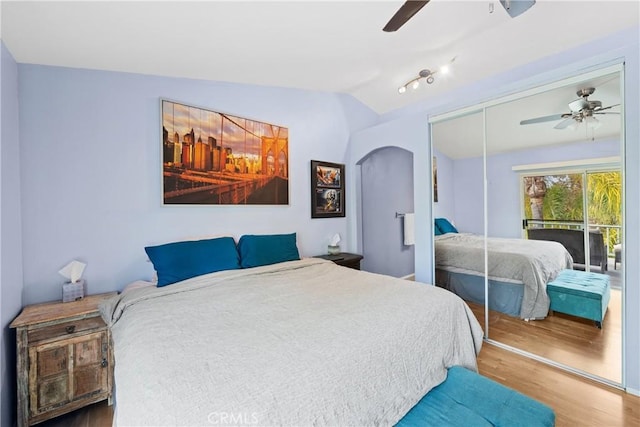 bedroom with ceiling fan, a closet, lofted ceiling, and wood-type flooring