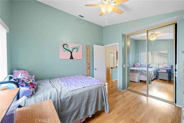 bedroom with ceiling fan, a closet, and light wood-type flooring