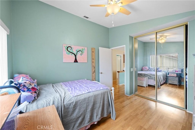 bedroom with ceiling fan, light hardwood / wood-style floors, and a closet