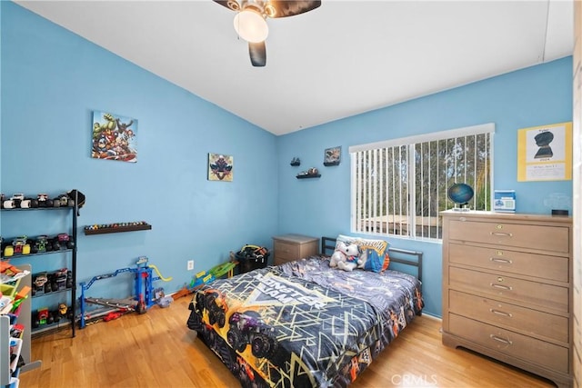 bedroom featuring light hardwood / wood-style flooring, ceiling fan, and vaulted ceiling