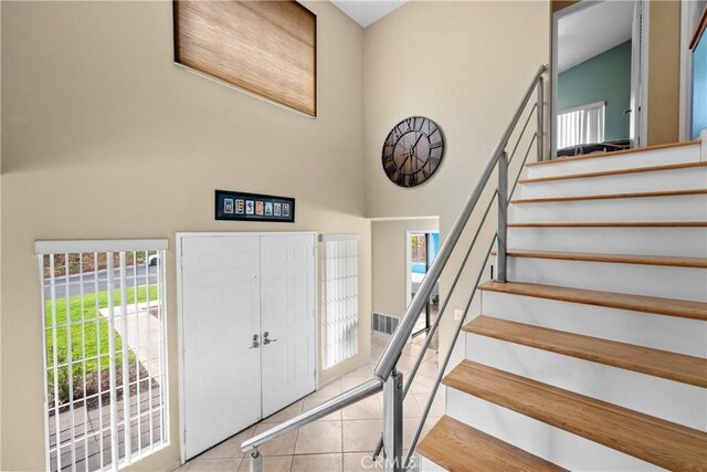 tiled foyer entrance featuring a towering ceiling