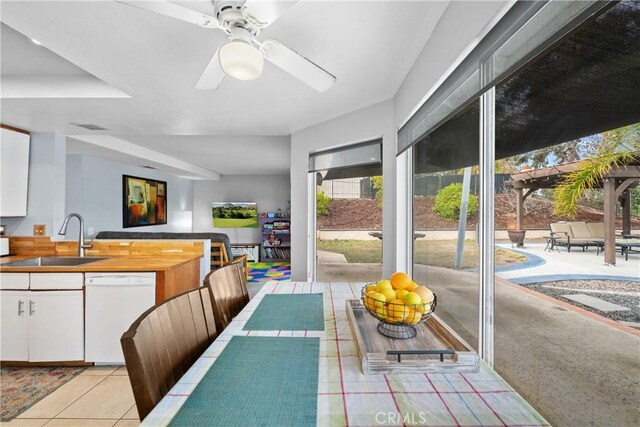 tiled dining room featuring ceiling fan and sink