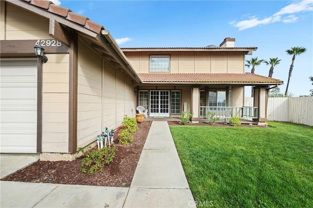 exterior space with a garage, a yard, and a porch