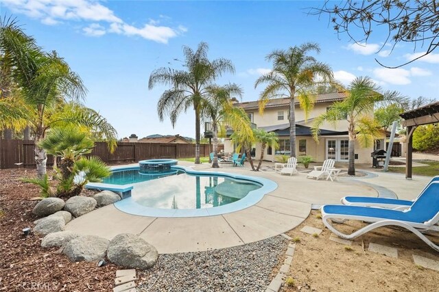 view of swimming pool with french doors, an in ground hot tub, and a patio area