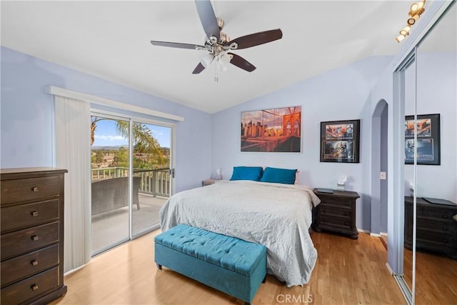 bedroom with a closet, access to exterior, vaulted ceiling, and light hardwood / wood-style flooring