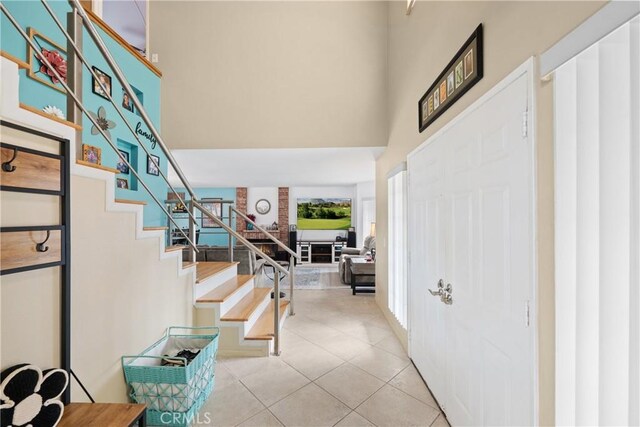 entrance foyer featuring a towering ceiling and light tile patterned floors