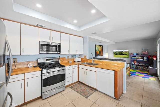 kitchen with stainless steel appliances, sink, and white cabinets