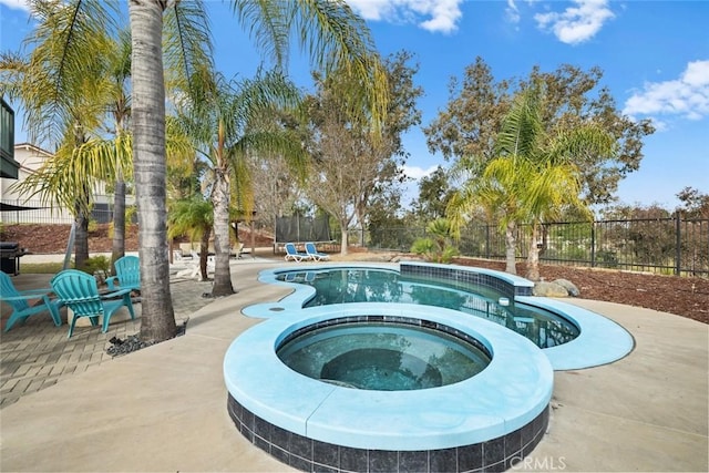 view of swimming pool featuring an in ground hot tub and a patio