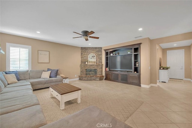 living room featuring light tile patterned floors, a fireplace, and ceiling fan