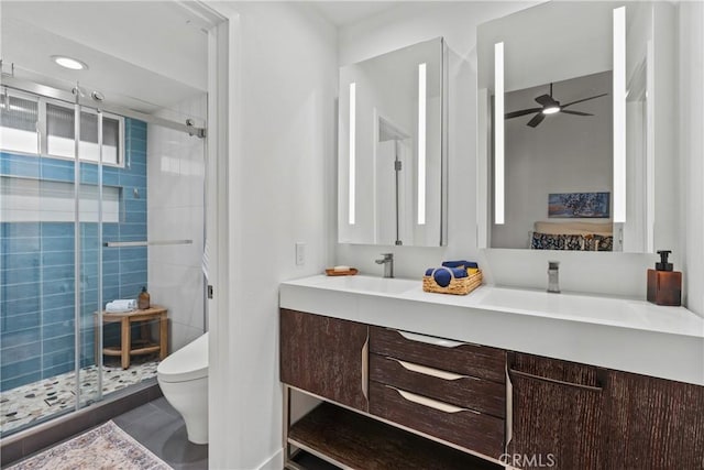 bathroom with toilet, an enclosed shower, vanity, ceiling fan, and tile patterned flooring