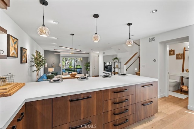 kitchen featuring decorative light fixtures and light hardwood / wood-style floors