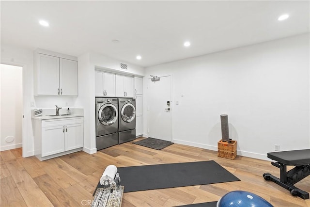 interior space featuring washer and clothes dryer, sink, and light hardwood / wood-style flooring