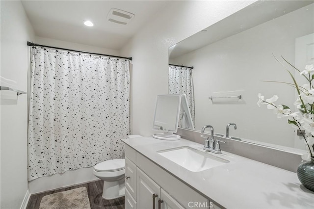 full bathroom with vanity, hardwood / wood-style flooring, toilet, and shower / bath combo with shower curtain