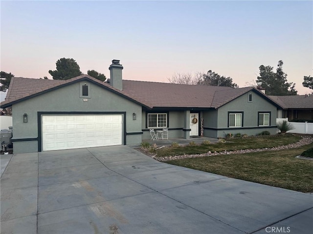 single story home with a garage and a lawn