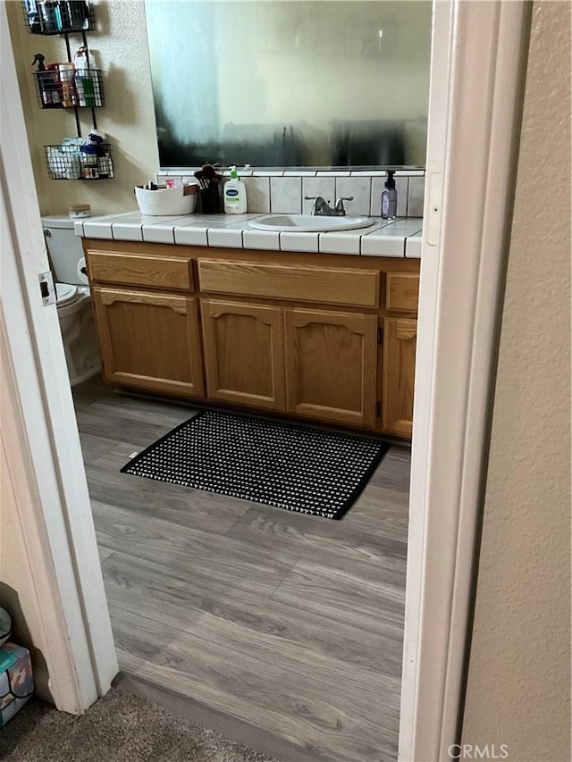 bathroom featuring vanity, hardwood / wood-style floors, and toilet