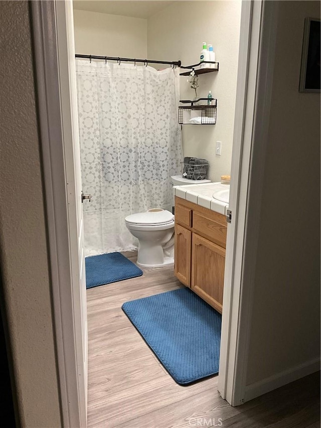 bathroom featuring vanity, hardwood / wood-style floors, and toilet