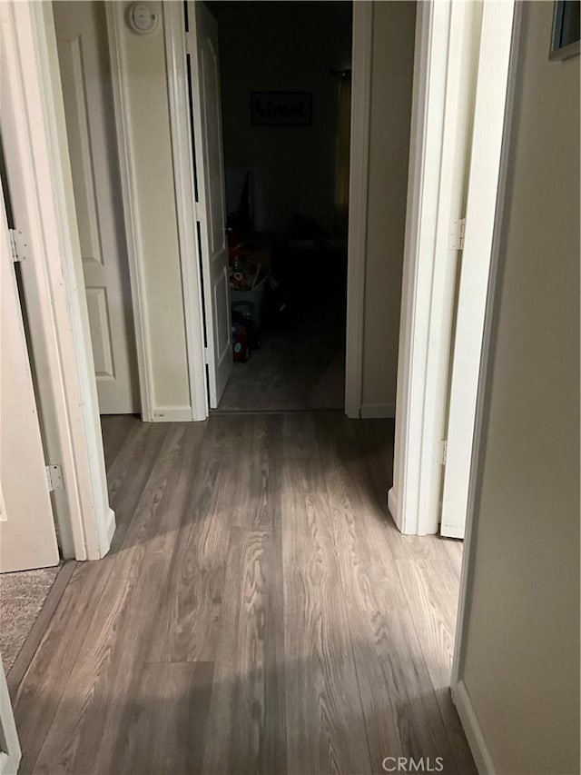 hallway with hardwood / wood-style flooring