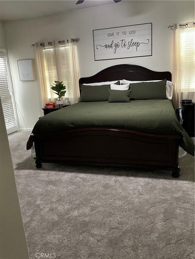 bedroom with multiple windows and light colored carpet