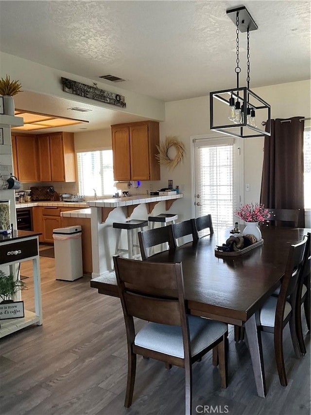 dining space with a textured ceiling and light wood-type flooring