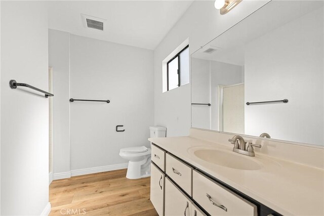 full bath with visible vents, baseboards, toilet, wood finished floors, and vanity