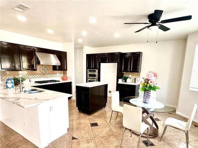 kitchen with sink, black gas stovetop, exhaust hood, stainless steel double oven, and white fridge