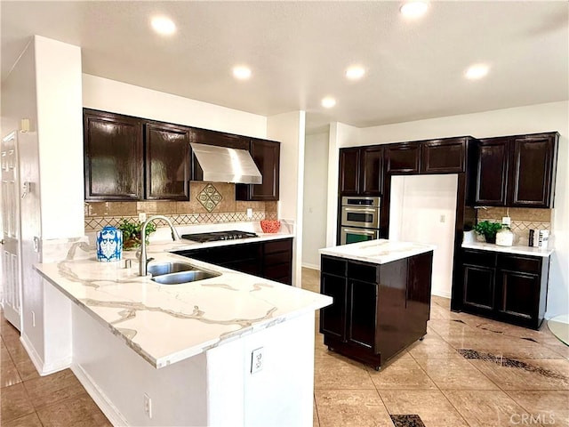 kitchen featuring extractor fan, sink, kitchen peninsula, black gas stovetop, and light stone countertops